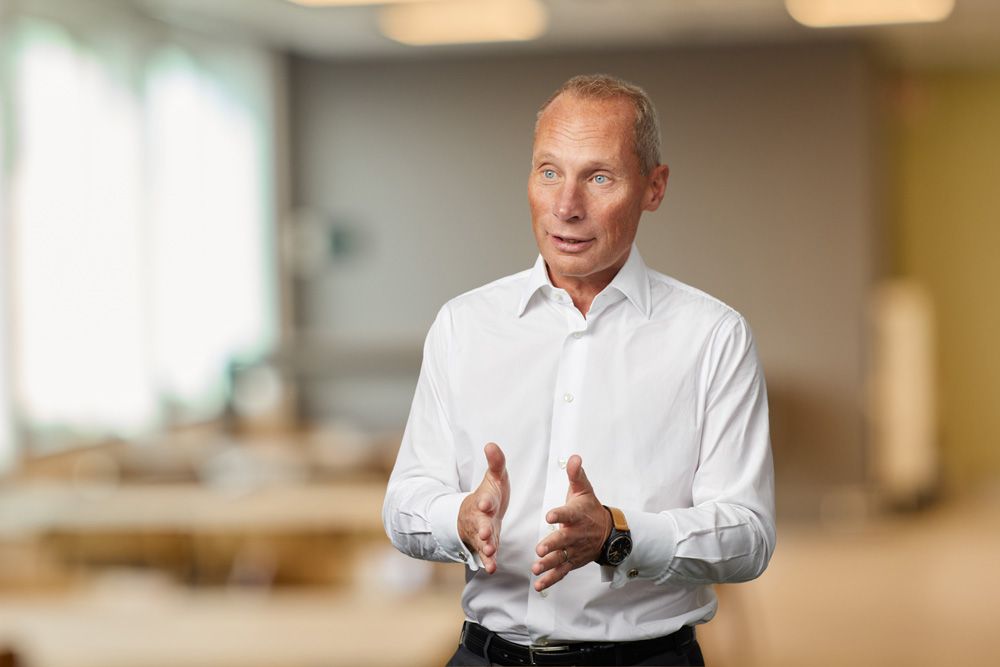 Vd står i ett rum i vit skjorta